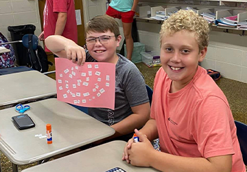 Two male students holding up school project